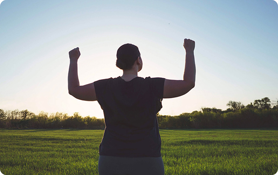 Mulher com excesos de peso feliz, com força e a sentir-se empoderada.